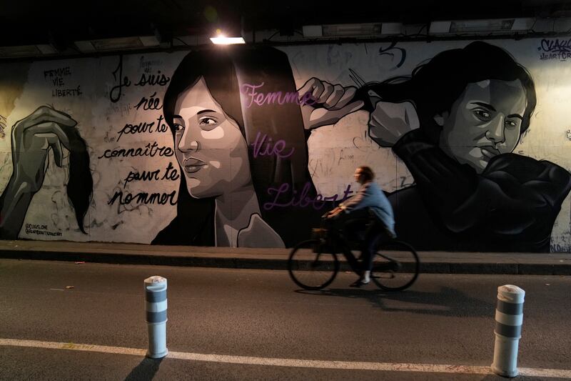 A mural in Paris depicts women cutting their hair to show support for Iranian protesters. AP