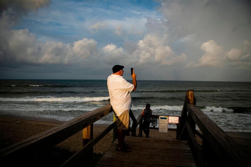 A man takes a photo  in Lantana Beach. AFP