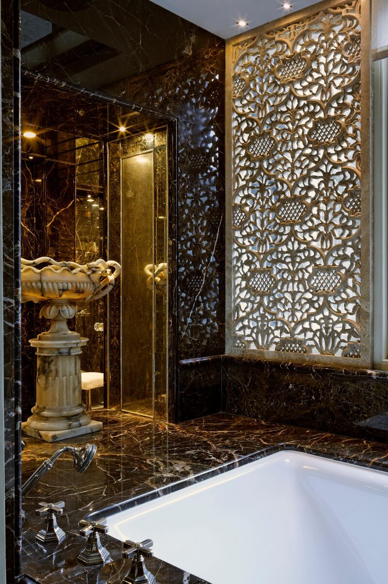 Detailed and complex solutions were used to make this London bathroom work as a room as well as a bathing space, and to do so every inch of it was designed with great care. Black marble, veined with white and gold, flows around the room, broken by mirror and verre Ã©glomisÃ© panels that give the appearance of size.  The carved marble Indian style screen infront of the main window above the bath, lends elegance and privacy but still allows natural light. (Photo by James McDonald)
