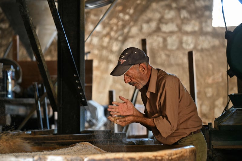 A man starts the milling process that turns whole grains into flour.