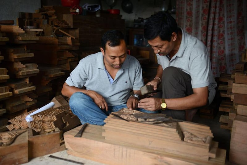 Nepalese woodcarver Indra Kaji Shilpakar, right, teaches his son Indra Prasad Shilpakar at his workshop in Bhaktapur. Prakash Mathema / AFP