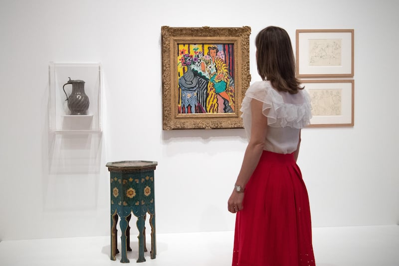 LONDON, ENGLAND - AUGUST 01:  (EDITORIAL USE ONLY. THIS IMAGE MAY ONLY BE USED IN THE CONTEXT OF THIS SPECIFIC EXHIBITION. NO ARCHIVING.) A member of staff poses next to works by Henri Matisse entitled (L-R) 'Jug', 'Small painted table (gueridon)', 'Yellow Odalisque', 'Pewter Jug: Hinge Studies' (top right) and 'Pewter Jug Studies' during a press preview for the forthcoming exhibition 'Matisse in the Studio' at the Royal Academy of Arts on August 1, 2017 in London, England. Matisse in the Studio is the first exhibition to consider how the personal collection of treasured objects of Matisse were both subject matter and inspiration for his work. 35 objects are displayed alongside 65 of Matisse's paintings, sculptures, drawings, prints and cut-outs. The exhibition runs from August 5 to November 12.  (Photo by Carl Court/Getty Images)