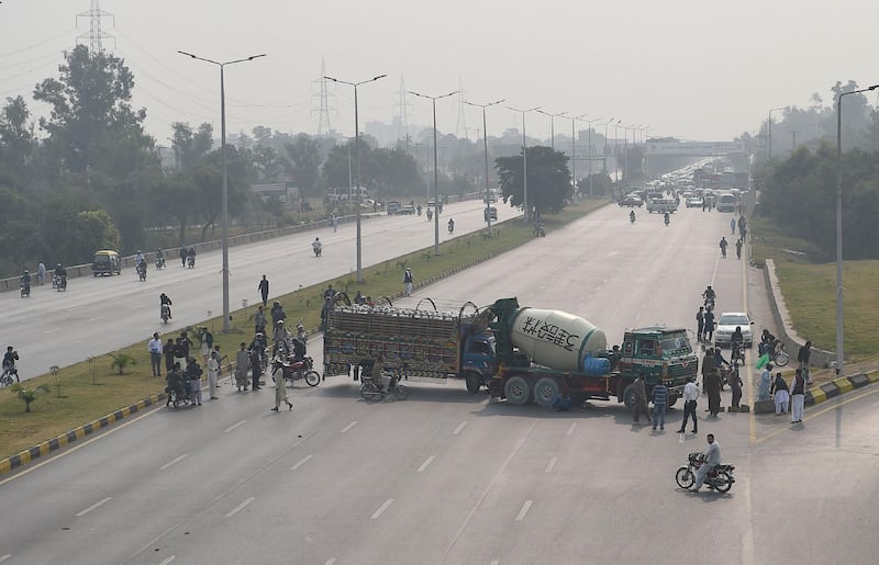 Supporters of a Pakistani religious group block the Islamabad Highway with trucks. AFP