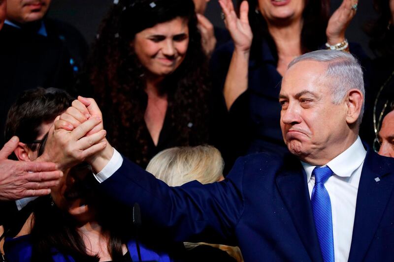 TOPSHOT - Israeli Prime Minister Benjamin Netanyahu reacts as he shakes hands with someone after addressing supporters at his Likud Party headquarters in the Israeli coastal city of Tel Aviv on election night early on April 10, 2019.  / AFP / Thomas COEX
