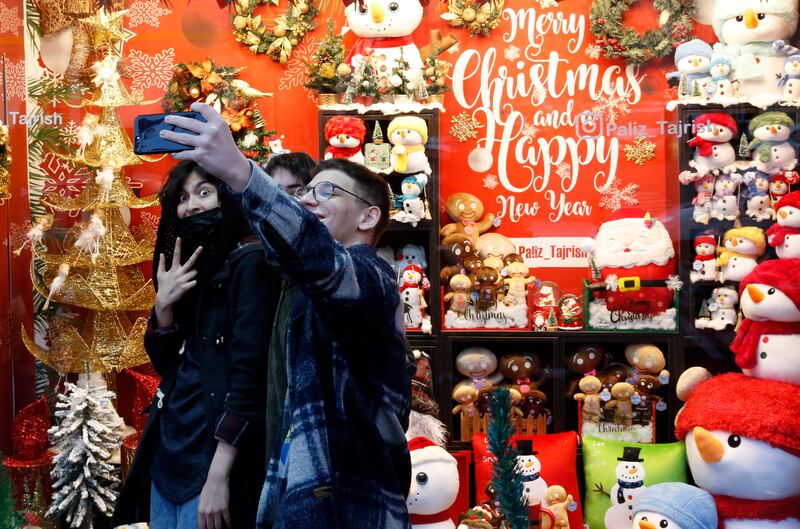 Young people take a selfie in front of a shop selling Christmas decorations in Tehran, Iran.  Approximately 150,000 Christians live in Iran, mostly Armenians, who celebrate Christmas in churches and at home. Many Muslim families have adopted, Christmas customs, buying presents and Christmas trees. EPA