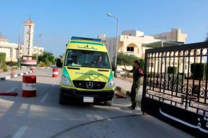 An ambulance carrying the bodies of Egyptian police officers leaves a hospital to head to the airport in Arish.