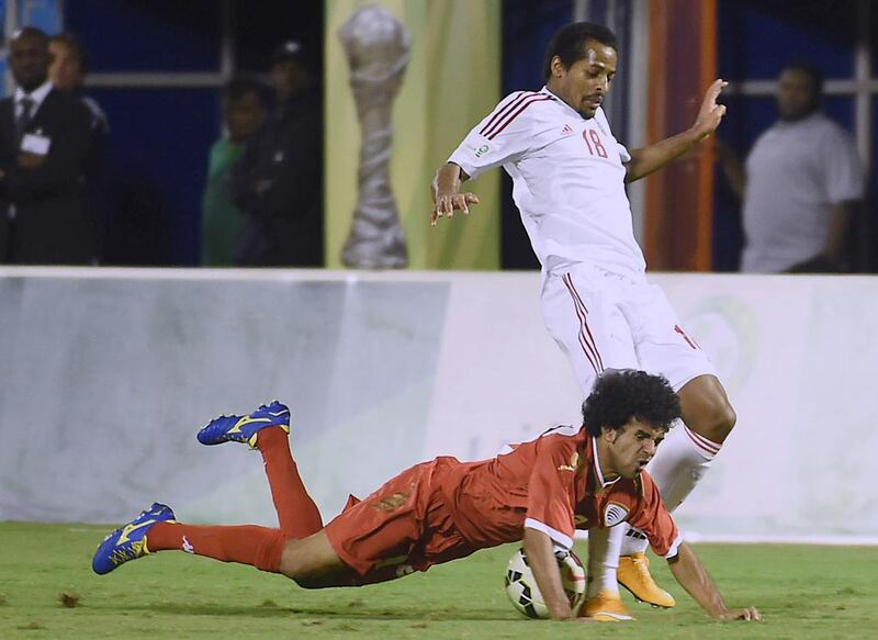 The UAE's Mohammed Fawzi, right, tackles Oman's Fahad Al Jalabubi during the third-place match at the 22nd Gulf Cup of Nations at the Prince Faisal bin Fahd Stadium in Riyadh on November 25, 2014. Fayez Nureldine / AFP