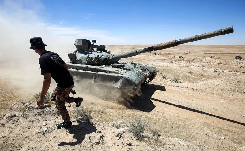 An Iraqi-modified T-72M tank belonging to the pro-government Hashed al-Shaabi (Popular Mobilisation) paramilitary forces advances towards the UNESCO-listed ancient city of Hatra, southwest of the northern city of Mosul, during an offensive to retake the area from Islamic State (IS) group fighters, on April 26, 2017.
Hatra is the latest important archaeological site to be recaptured from IS. 
Jihadists had embarked on a campaign of destruction against archaeological sites after they seized swathes of Iraq and Syria in a lightning 2014 offensive. 
The full extent of the harm to Hatra remains unclear. / AFP PHOTO / AHMAD AL-RUBAYE