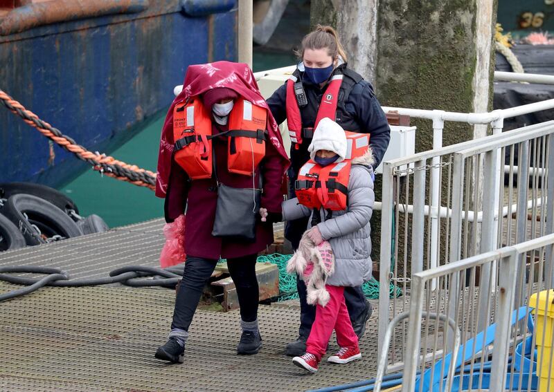 People thought to be migrants are guided after being brought into port by Border Force officers following a small boat incident in the Channel, at Dover southern England, Monday March 8, 2021. (Gareth Fuller/PA via AP)