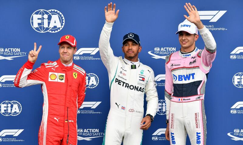 Mercedes driver Lewis Hamilton of Britain, center, who got pole position, poses with second in qualifying Ferrari driver Sebastian Vettel of Germany, left, and third in qualifying Force India driver Esteban Ocon of France at the Belgian Formula One Grand Prix in Spa-Francorchamps, Belgium, Saturday, Aug. 25, 2018. The Belgian Formula One Grand Prix will take place on Sunday, Aug. 26, 2018. (AP Photo/Geert Vanden Wijngaert)