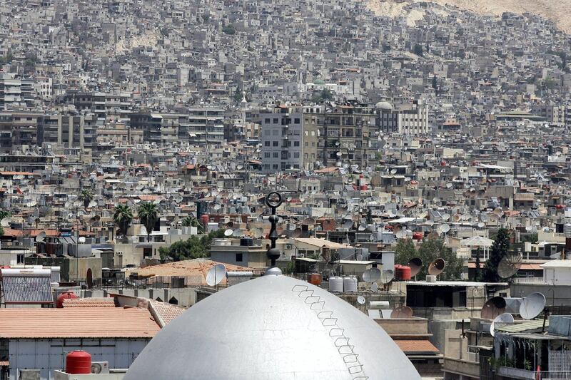 The dome of a mosque is seen amongst satellite dishes on the rooftops of home and apartment blocks in the Syrian capital Damascus, on June 26, 2013. AFP PHOTO / LOUAI BESHARA (Photo by LOUAI BESHARA / AFP)