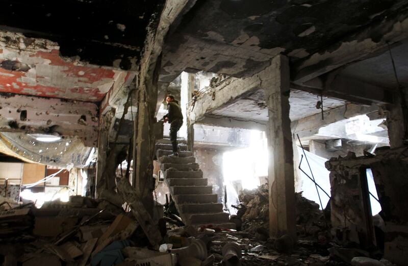 A man stands on a staircase inside a demolished building in the Yarmouk Palestinian refugee camp in the Syrian capital Damascus on April 6, 2015. Around 2,000 people have been evacuated from the camp after ISIL seized large parts of it. Youssef Karwashan/AFP Photo