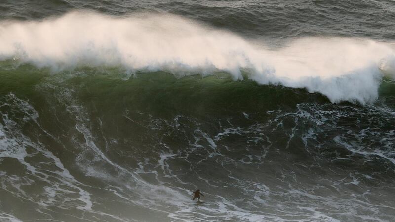 A surfer rides a wave at Praia do Norte or North Beach in Nazare, Portugal, on Sunday, December 22. AP