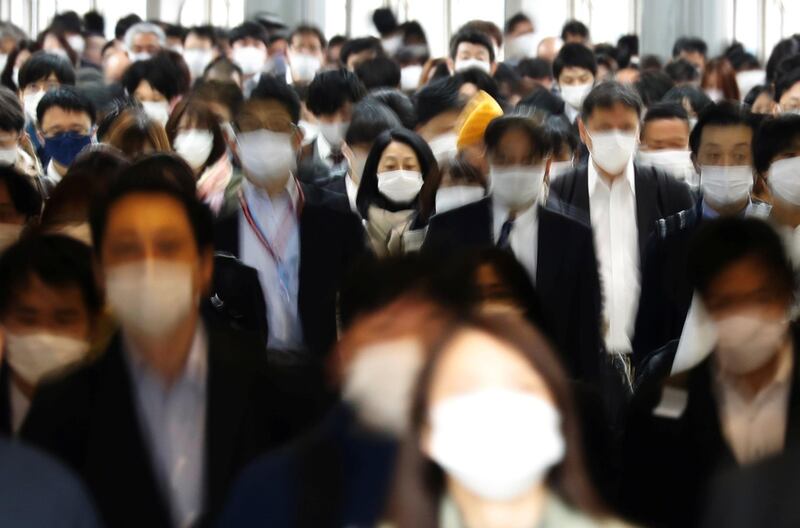 Commuters wearing protective masks make their way in Tokyo, Japan. Reuters