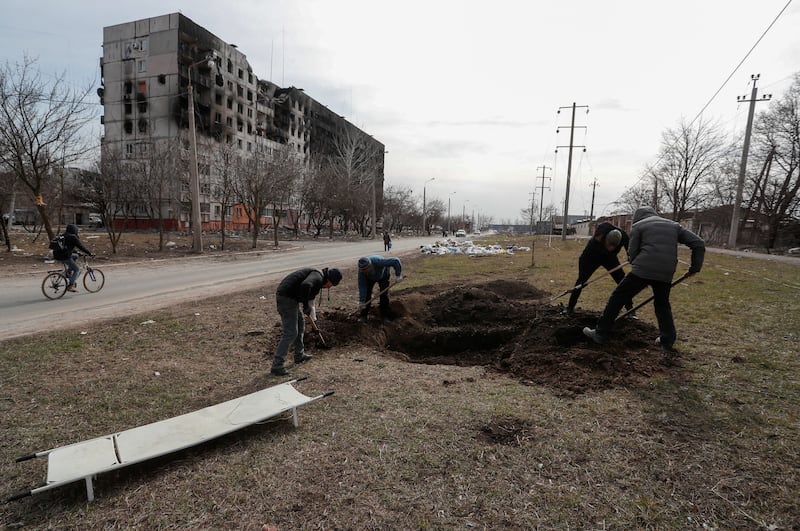 Graves are dug in a street in the besieged southern port city of Mariupol. Reuters