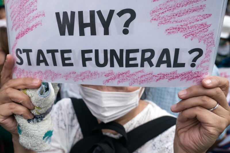 A woman holds a placard during a protest against the funeral. Getty Images