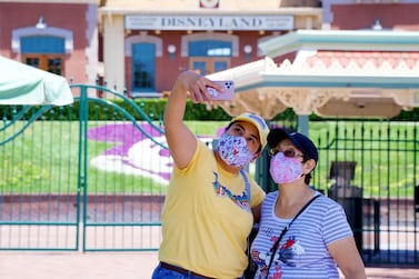 Maria Delgadillo takes a selfie with her mother on the reopening day of the Downtown Disney District in Anaheim, California. The Orange County Register via AP