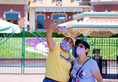 Maria Delgadillo takes a selfie with her mother Rosa Torres at the entrance to Disneyland on the reopening day of the Downtown Disney District on its reopening day in Anaheim, Calif., Thursday, July 9, 2020. (Jeff Gritchen/The Orange County Register via AP)