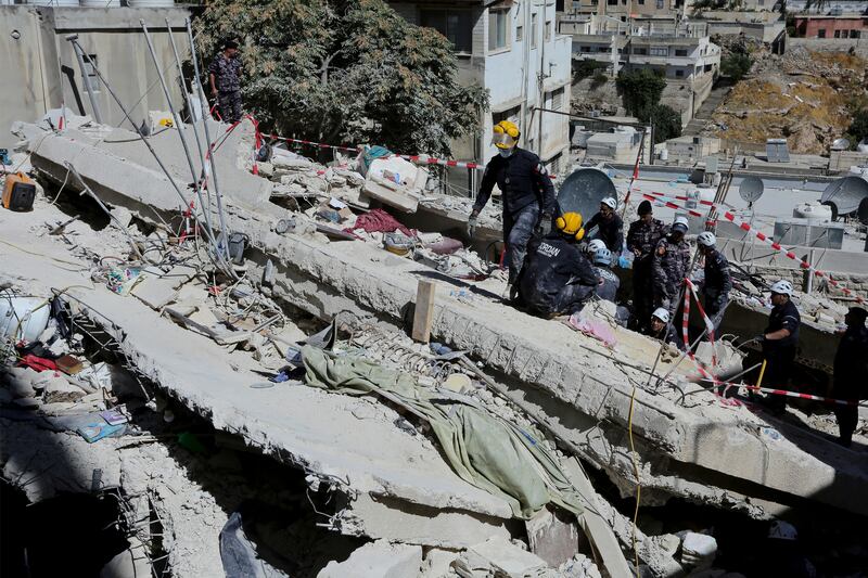 Rescue teams from the Jordanian Civil Defence search for residents of the four-storey apartment building that collapsed. AP