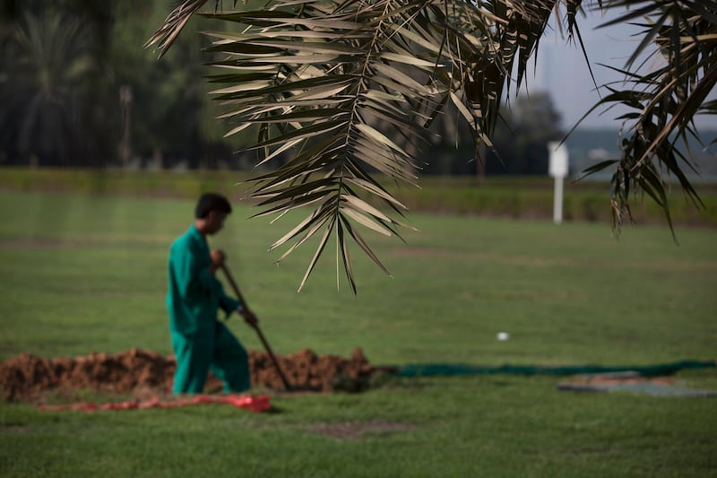ABU DHABI, UNITED ARAB EMIRATES, Sep. 25, 2014:  
Workers dig a ditch for electrical cables for irrigation system at  the green and lush traditional park space at Salaam Street near where it meets 19th (Al Sa'ada Street) features expansive grass area and a dolphin fountain on Thursday, Sep. 25. On the other side of the Salaam Street is a new desert-style landscape, with very different plants and a marked absence of irrigation. (Silvia Razgova / The National)

Usage: Sep. 28, 2014
Section: WK
Reporter:  Nick Leech


