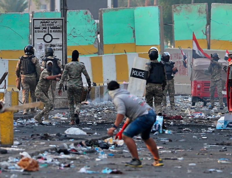 A protester throws a stone during clashes between Iraqi security forces and anti-government demonstrators, in downtown Baghdad. AP Photo