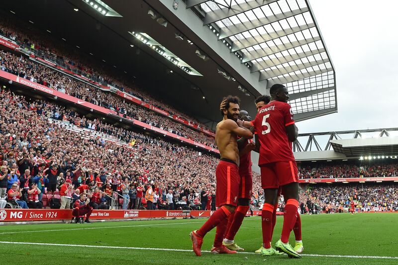 Liverpool's Egyptian midfielder Mohamed Salah (L) celebrates with teammates after scoring their second goal during the English Premier League football match between Liverpool and Crystal Palace at Anfield in Liverpool, north west England on September 18, 2021.  (Photo by Paul ELLIS / AFP) / RESTRICTED TO EDITORIAL USE.  No use with unauthorized audio, video, data, fixture lists, club/league logos or 'live' services.  Online in-match use limited to 120 images.  An additional 40 images may be used in extra time.  No video emulation.  Social media in-match use limited to 120 images.  An additional 40 images may be used in extra time.  No use in betting publications, games or single club/league/player publications.   /  