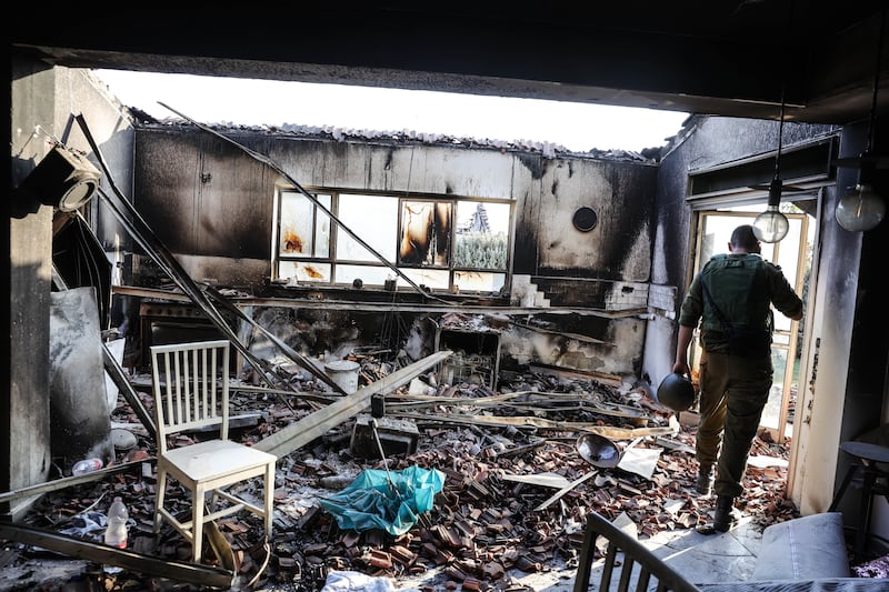 An Israeli soldier in a ruined house in the kibbutz of Beeri, near the border with Gaza. EPA