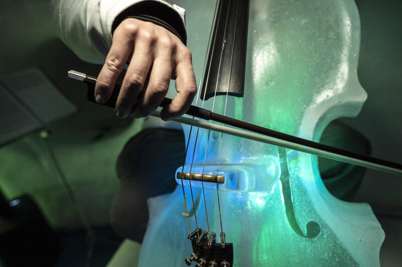 A musician performs with an ice cello during a concert. AFP