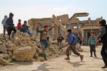 Children in the village of Kufayr, Idlib province, play in the yard of a school that was badly damaged during fighting. AFP