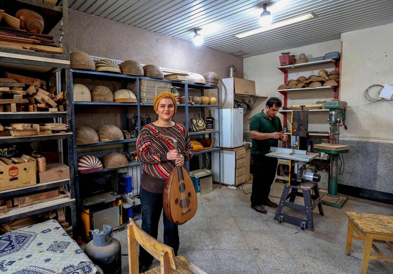 Iranian luthier Fatemeh Moussavi poses for a picture at her oud-making workshop in the  capital Tehran, on December 14, 2020. The Oriental lute, known as the oud in Arabic, the barbat in Persian, is making a comeback in Iran after decades of neglect as musicians reconnect with an instrument integral to Arab and Turkish musical tradition in a fragmented region. / AFP / ATTA KENARE
