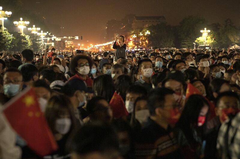 Members of the public attend the flag raising ceremony in Tiananmen Square during National Day in Beijing. Bloomberg