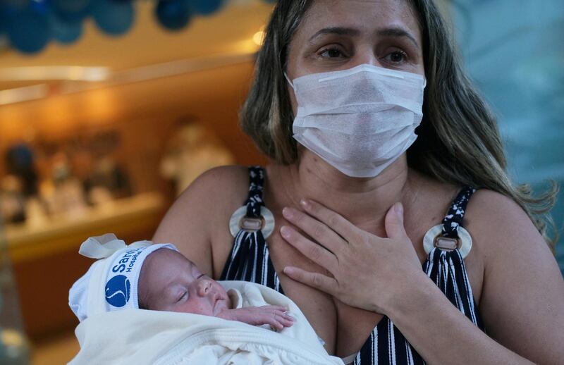 Rusia Goes, a nurse who gave birth on April 26 hooked to a ventilator tube to help her breath as she battled severe symptoms of Covid-19, carries her daughter Luisa, after she was released from the hospital in Rio de Janeiro, Brazil. Reuters