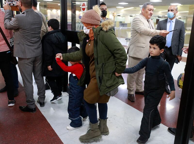 An Iraqi woman arrives with two children at the airport in Baghdad after being flown home from the Belarusian capital Minsk. AFP