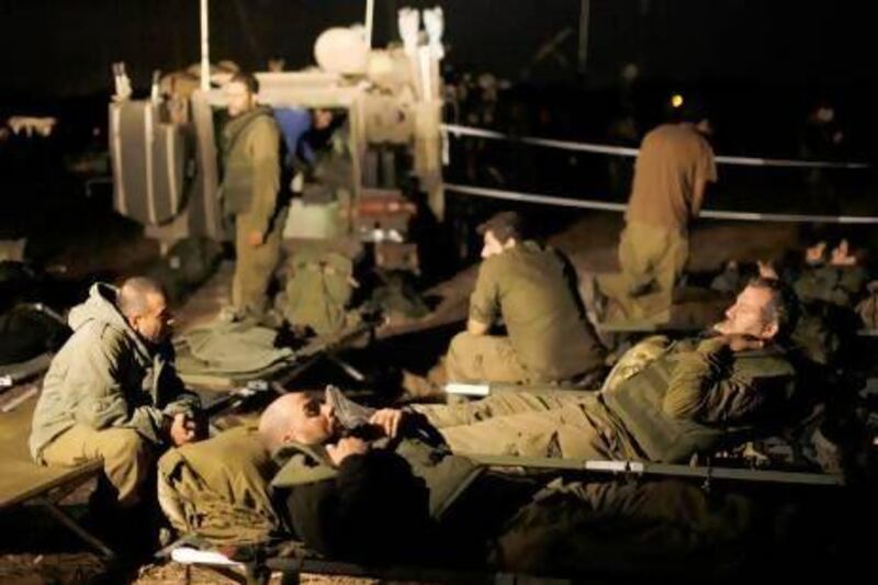 Israeli soldiers rest outside the northern Gaza Strip. Israel and Hamas agreed yesterday to a ceasefire brokered by Egypt on the eighth day of the conflict.