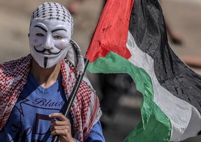 epa07572844 A Palestinian protester wearing a Guy Fawkes mask takes part during the clahses near the border between Israel and eastern Gaza Strip, 15 May 2019. Palestinians are marking Nakba Day, or Day of the Catastrophe, which is marked on 15 May to commemorate the expulsion of more than 700,000 Palestinians from their land in the war surrounding the establishment of the state of Israel.  EPA/MOHAMMED SABER