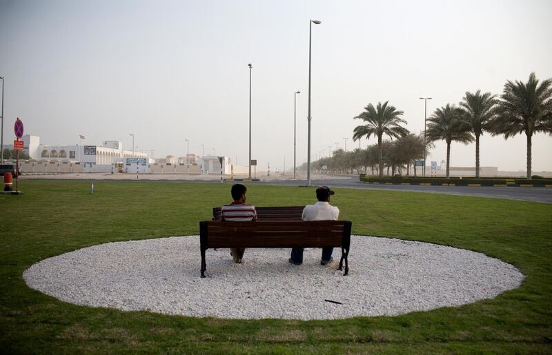 Al Sila, UAE - February 22, 2009 - Two men sit on a park bench in one of the few grassy areas in Al Sila. Al Sila is the last town in the south of UAE before crossing the border to Saudi Arabia. (Nicole Hill / The National) *** Local Caption ***  NH Sila28.jpgNS28MR SILA 01.jpg