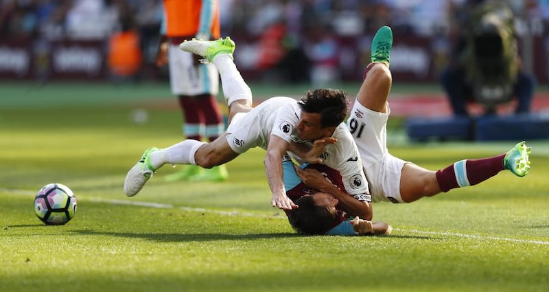 West Ham United's Mark Noble tumbles with Swansea City's Jack Cork in a battle for possession. Eddie Keogh / Reuters