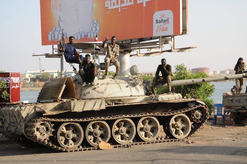 Sudanese army soldiers sit on top of a tank in the Red Sea city of Port Sudan on April 20. AFP