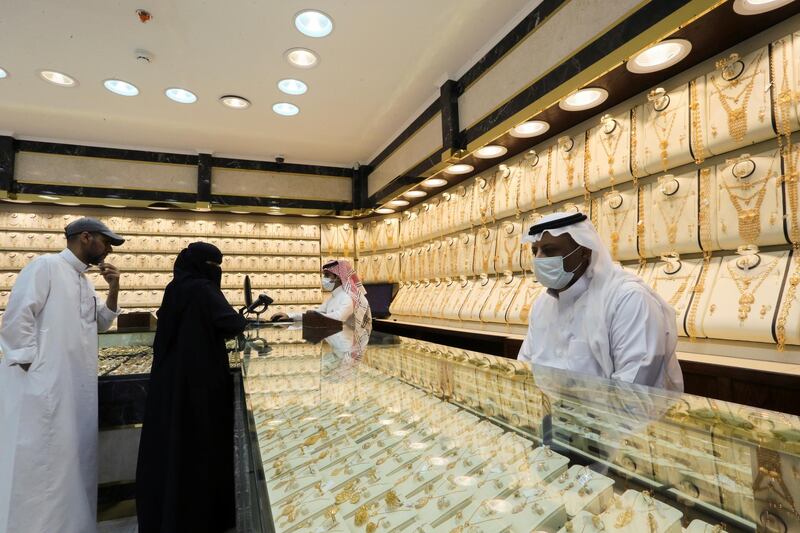 Saudi jewellers wearing protective face masks stand as people shop at a store in Riyadh. Reuters