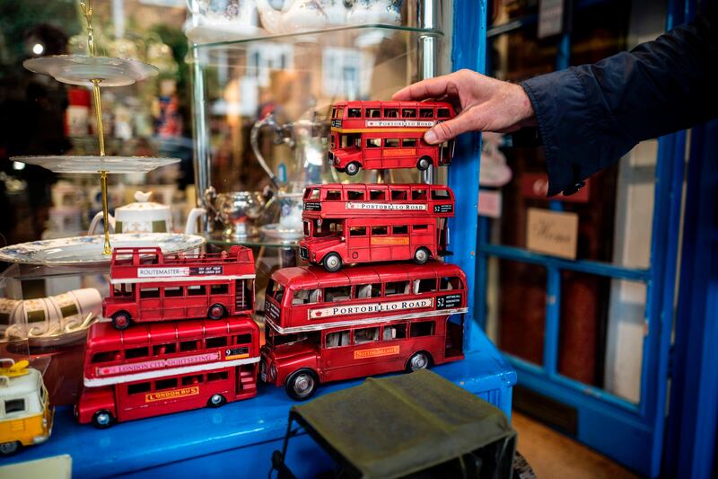 A customer looks a model of a red London Bus outside a shop on the Portobello Road Market in the Notting Hill district of west London, on August 8, 2017.
Last week, The Bank of England cut its UK growth forecasts with governor Mark Carney warning that high inflation triggered by a Brexit-fuelled slump in the pound had hurt consumer spending. / AFP PHOTO / Tolga Akmen