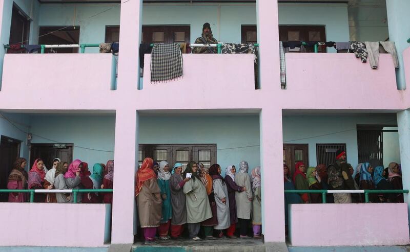 An Indian paramilitary soldier stands guard as Muslim women stand in a queue waiting for their turn to cast votes in Chadoora, Indian Kashmir. Farooq Khan/EPA