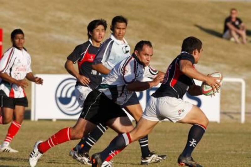 Dubai, United arab Emirates, Dec 10 2011, Emirates Airlines Cup of Nations- (centre) Uae's Mike Riley reaches to take down an Hong Kong ball carrier in the  Emirates Airlines Cup of Nations. Mike Young / The National? 
Rugby Action