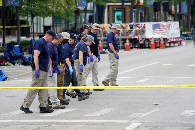 Members of the FBI's evidence response team walk the scene one day after the mass shooting. AP 