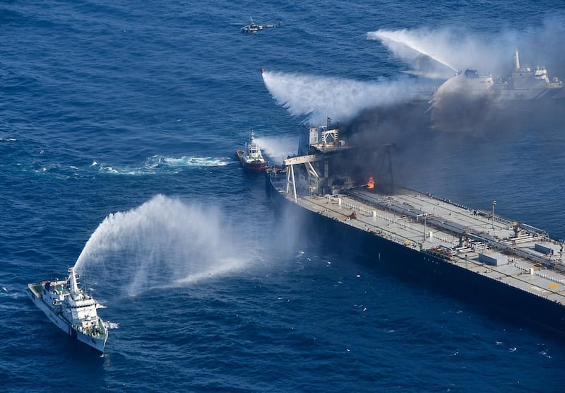 The military helicopter, coast guard ships and fireboats battle to extinguish the fire from the Panama-flagged crude oil vessel MT New Diamond at off the east coast of Sri Lanka. EPA