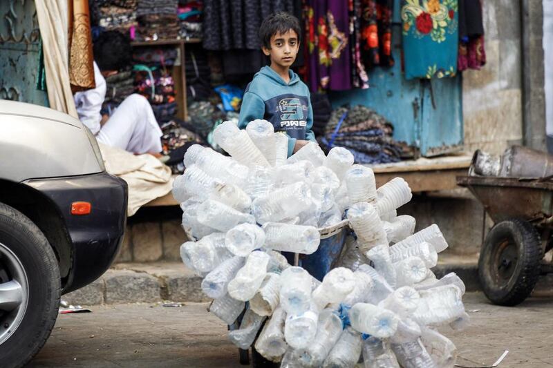A Yemeni child collects old water bottles at a market in Sanaa's Suq Al Melh (Salt Market) on January 24, 2017. Mohammed Huwais / AFP