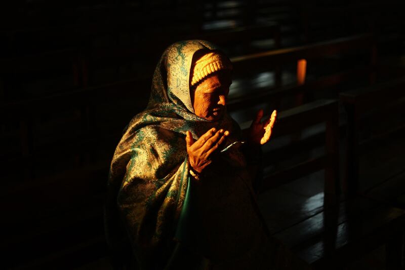A Christian prays at a Christmas mass on a cold winter morning in Chandigarh. AFP