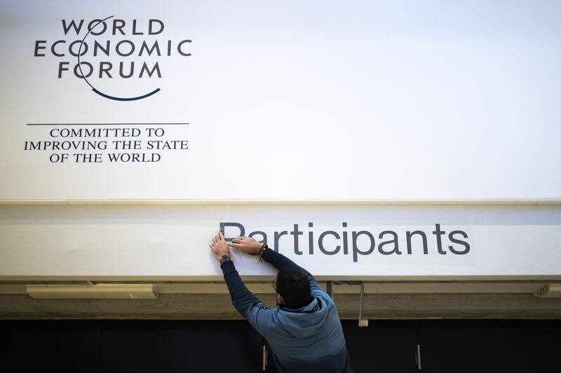 A sign goes up in the main hall of the Davos Congress Centre on Sunday. EPA