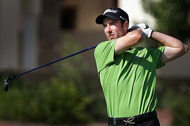 Ross Fisher watches a shot on his way to matching the course record and a share of the lead.