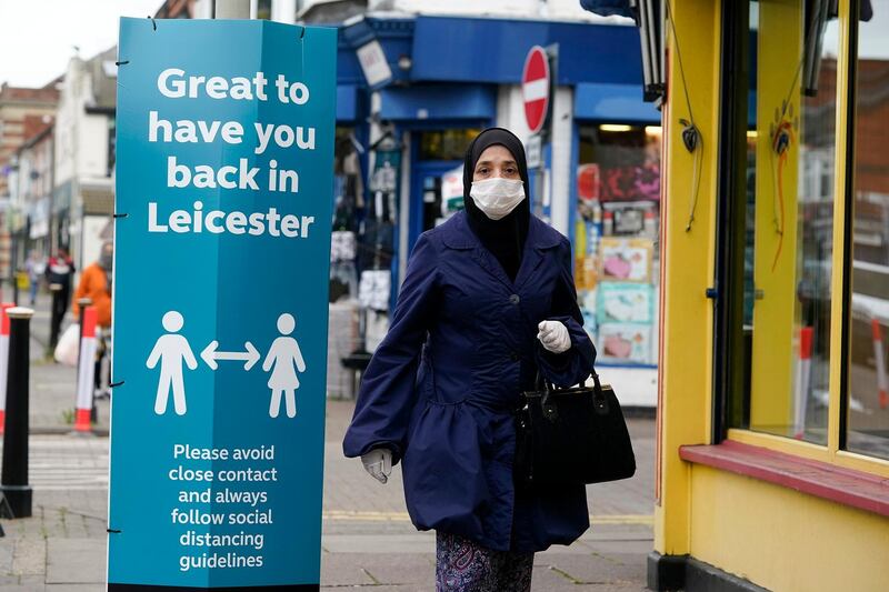 LEICESTER, ENGLAND - JUNE 29: A woman wearing a PPE mask walks past social distance advisory singns in Leicester's North Evington neighbourhood on June 29, 2020 in Leicester, England. In a television appearance on Sunday, British Home Secretary Priti Patel confirmed the government was considering a local lockdown after a spike in coronavirus cases in the city. The city's mayor has said that Pubs and restaurants in Leicester may stay closed for two more weeks due to a recent surge in coronavirus cases. (Photo by Christopher Furlong/Getty Images)
