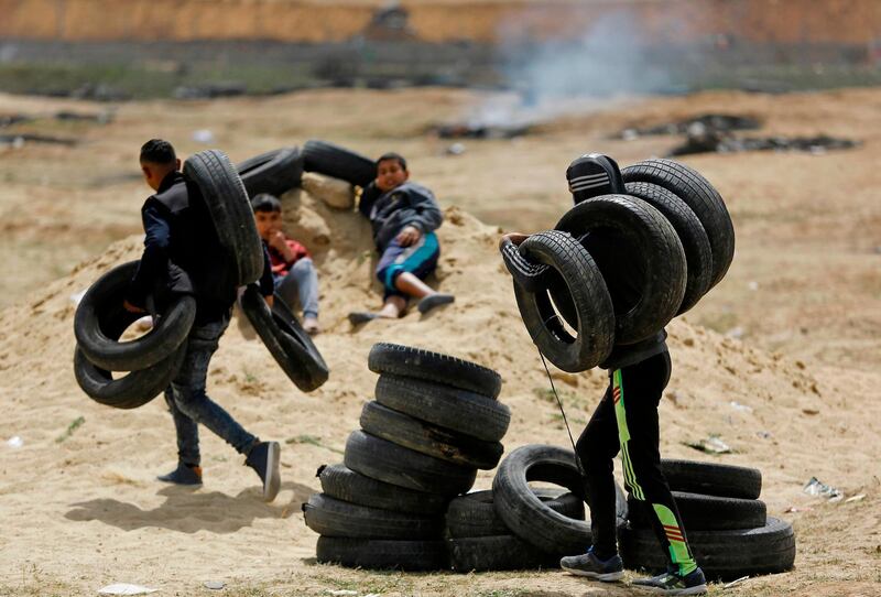 Palestinians prepare to burn tires during a protest at the border fence with Israel, east of Jabalia in the central Gaza city, on April 13. Mohammed Abed / AFP Photo